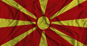 Nordmazedonien Drucke: Mazedonische Flagge mit Stofftextur-Hintergrund.