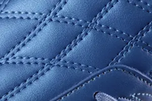 Bilder Datiert 9. Januar 2024: Die makrotextur eines blauen Ledersneakers mit Nähten.