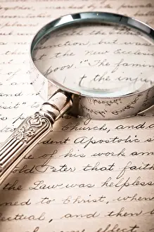 Close Up Detail View Photo Drucke: A magnifying glass over antique cursive script