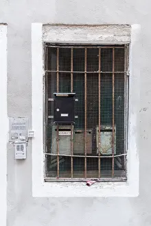 Briefkästen hinter einem verzierten Fenster