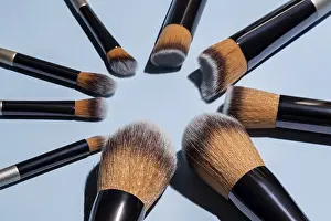 Full Frame Beauty Shot Drucke: Make up brushes arranged in a circle on blue background