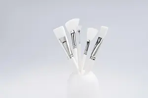 Clear Glass Container Drucke: Make up brushes of different size and type in a glass against light blue background