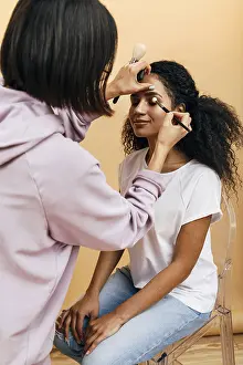 Beauty Studio Photography Drucke: Makeup artist applying eye make up on model in studio