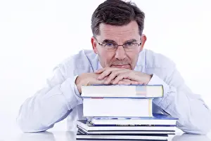 Pensive Businessman Drucke: Man, 50+, leaning on a stack of books