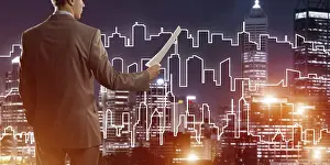Caucasian Male Professional Drucke: Man architect or engineer presenting construction concept and holding documents in hand