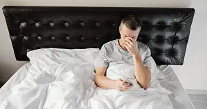 Dark Bedroom Scene Drucke: Man bed using mobile
