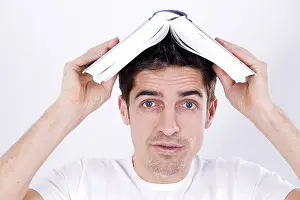 Caucasion Ethnicity Photo Shoot Drucke: Man with a book on his head