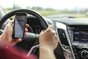 Road Traffic Accident Drucke: Man checking his text messages while driving
