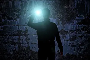 Gloomy Atmosphere Drucke: Man with flashlight in dark urban setting