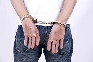 Studio Shot Of A Prisoner Drucke: Man with handcuffs