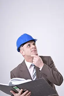 Man In Hard Hat Drucke: Man with hard hat and file, thinking