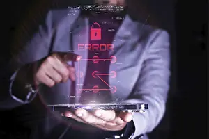 Cybersecurity Threats Drucke: A man interacts with a virtual error message related to security on a transparent digital device