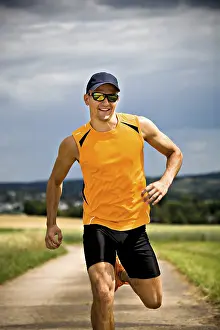 Athletic Man Drucke: Man jogging through the fields