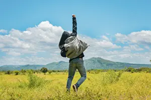 Farmland Landscape Photo Drucke: Man from back jumping in a nice field