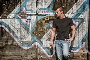 Graffiti Art Drucke: A man leaning against a wall with graffiti on it