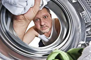 Washing Machine Interior View Drucke: Man loading cloths to washing machine