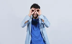 Self Confident Man Drucke: Man making binoculars gesture isolated