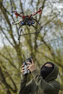 Quadcopter Aerial View Drucke: Man in mask operating a drone with remote control