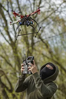 Quadcopter Aerial View Drucke: Man in mask operating a drone with remote control