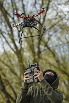Quadcopter Aerial View Drucke: Man in mask operating a drone with remote control
