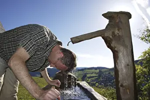 Southern Germany Historic Image Drucke: A man in his mid 40s cools off at a well