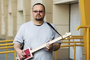 Man Playing Guitar Drucke: Man playing his three string cigar box guitar