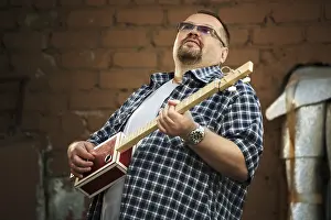 Man Playing Guitar Drucke: Man playing his three string cigar box guitar