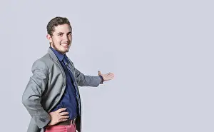 Young Man In Suit Drucke: Man pointing back and presenting a product