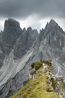 Dolomites Landscape Photography Drucke: Man with red jacket standing on one degree