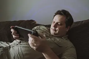 Cozy Living Room Drucke: A man relaxes on a comfortable couch