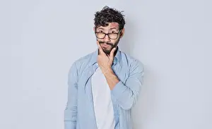 Hispanic Ethnicity Model Drucke: Man rubbing his beard with an expression of doubt