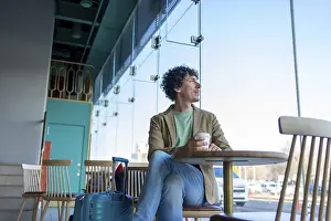 Modern Architecture Photography Drucke: A man sits at a cafe table with coffee