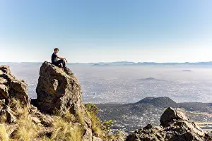Nature Tourism Images Drucke: A man sits on a large rock