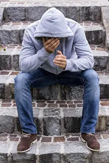 Single Person In Europe Drucke: A man sits alone on steps Austria
