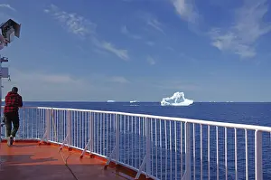 Winter Travel Photography Drucke: Man standing at the rail of a ship with his back to the camera