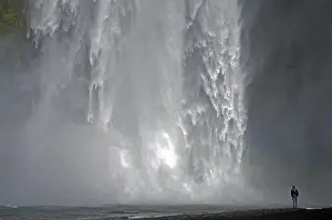 Waterfall Photography Drucke: A man stands in front of an impressive waterfall