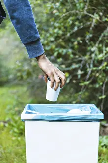 Environmental Protection Drucke: Man throwing up garbage bin