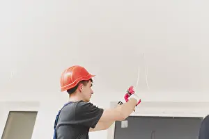 Construction Industry Jobs Drucke: Man working with cables ceiling
