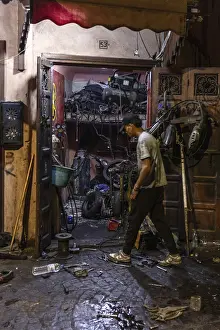 Deserted Workshop Scene Drucke: A man works at night in a workshop full of tools and clutter