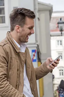 Mobile Phone Communication Drucke: A man writes a text message on his mobile phone