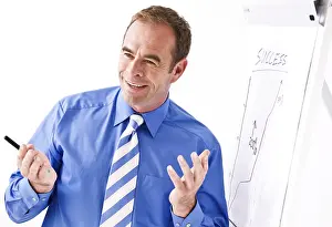 Business Executive Drucke: Manager smiling, standing in front of a flipchart