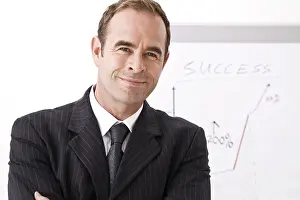 Businessman Smiling Drucke: Manager smiling, standing in front of a flipchart