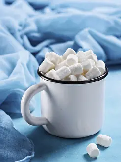 Blue Background Image Drucke: Marshmallows in cup on blue background with copyspace