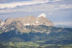 Cloudy Mountain Scenery Drucke: Massive mountain range under dramatic cloud formations and dense forest