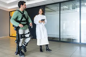 Medical Innovation Drucke: Mechanical exoskeleton, female doctor physiotherapist walking with disabled person helped by robotic skeleton
