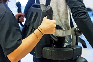 Mechanical Exoskeleton Drucke: Mechanical exoskeleton. Female physiotherapy medical assistant helping disabled person with robotic skeleton to walk