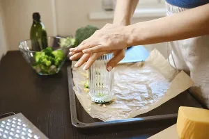 Kitchen Utensil Usage Drucke: Broccoli is being smashed using a glass in a kitchen