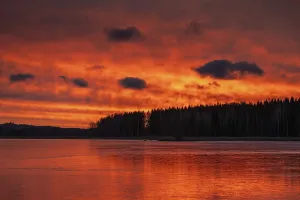 Atmospheric Evening Light In Nature Drucke: A dramatic sunset over a still