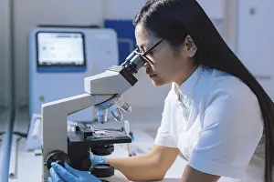 Scientific Research Lab Drucke: Medical laboratory scientist perform tests on patient samples using a microscope