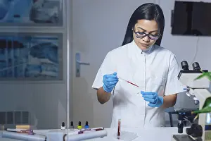 Scientific Research Lab Drucke: Medical laboratory scientist perform tests on patient samples using a microscope